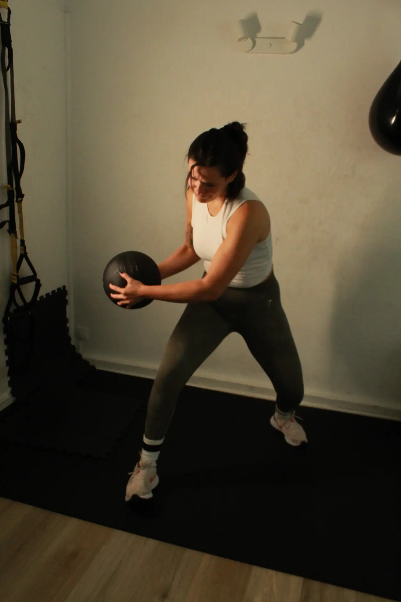 Lilia Slimi rotating with a medicine ball in the studio